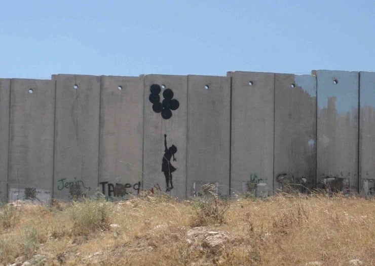 Banksy’nin Gazze’deki duvar eseri — balonlara tutunan kız silueti, savaşın sessizliği teması.